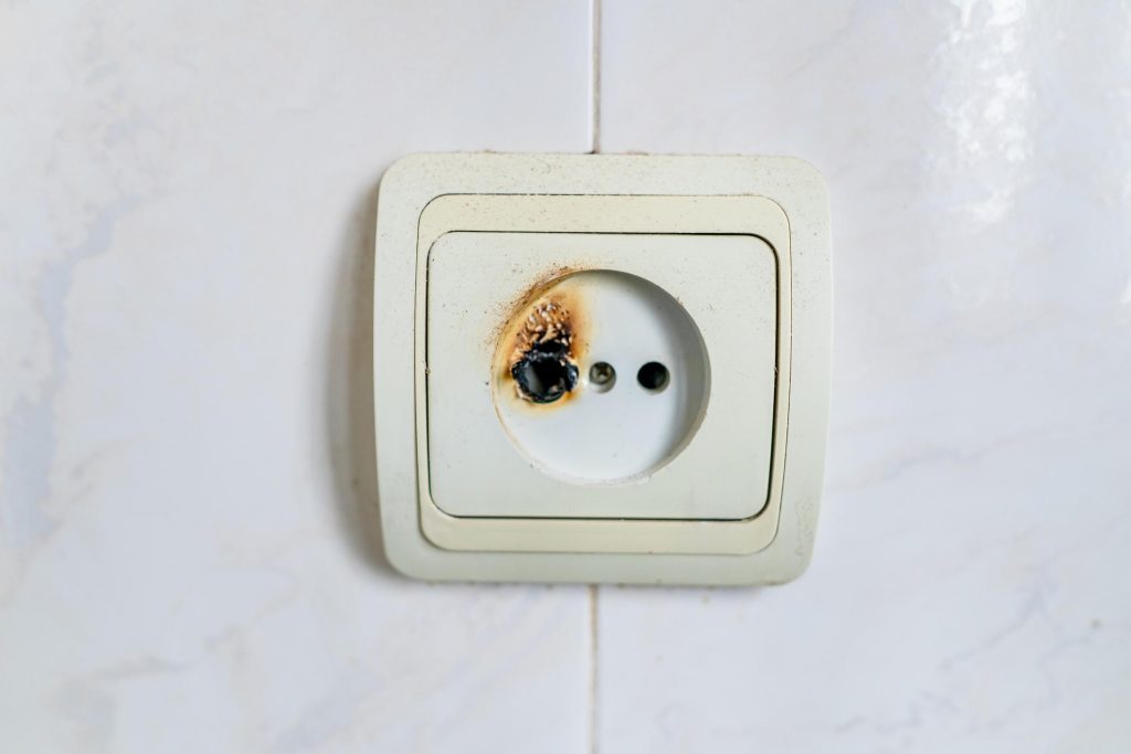 Burnt plug socket showing electrical damage and overheating