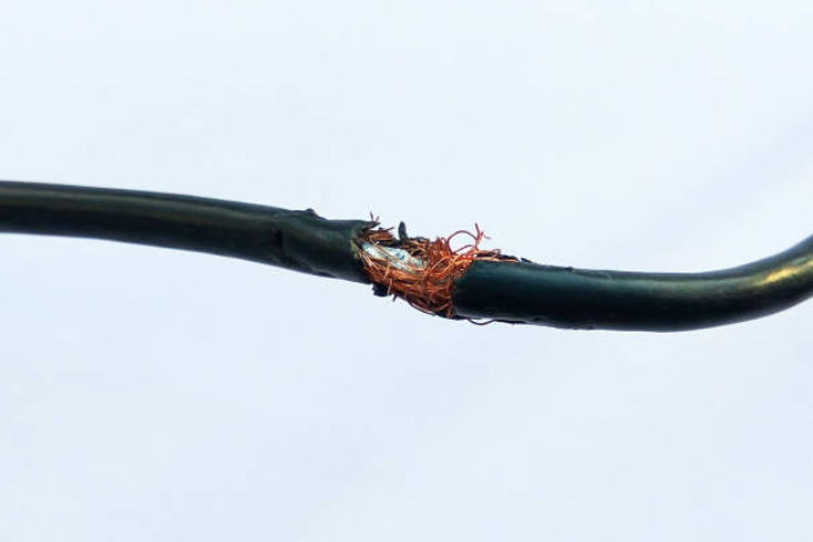 Faulty electrical wiring showing damaged cables inside a wall