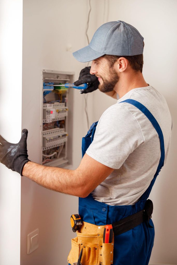 Electrician using a checklist while inspecting an electrical system in a home.