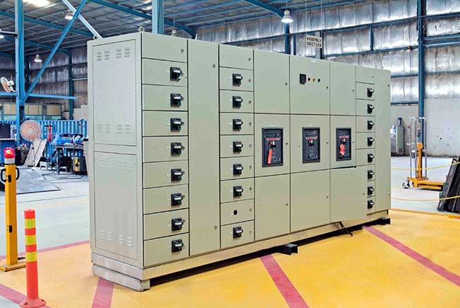 Industrial electrician inspecting a factory electrical distribution panel